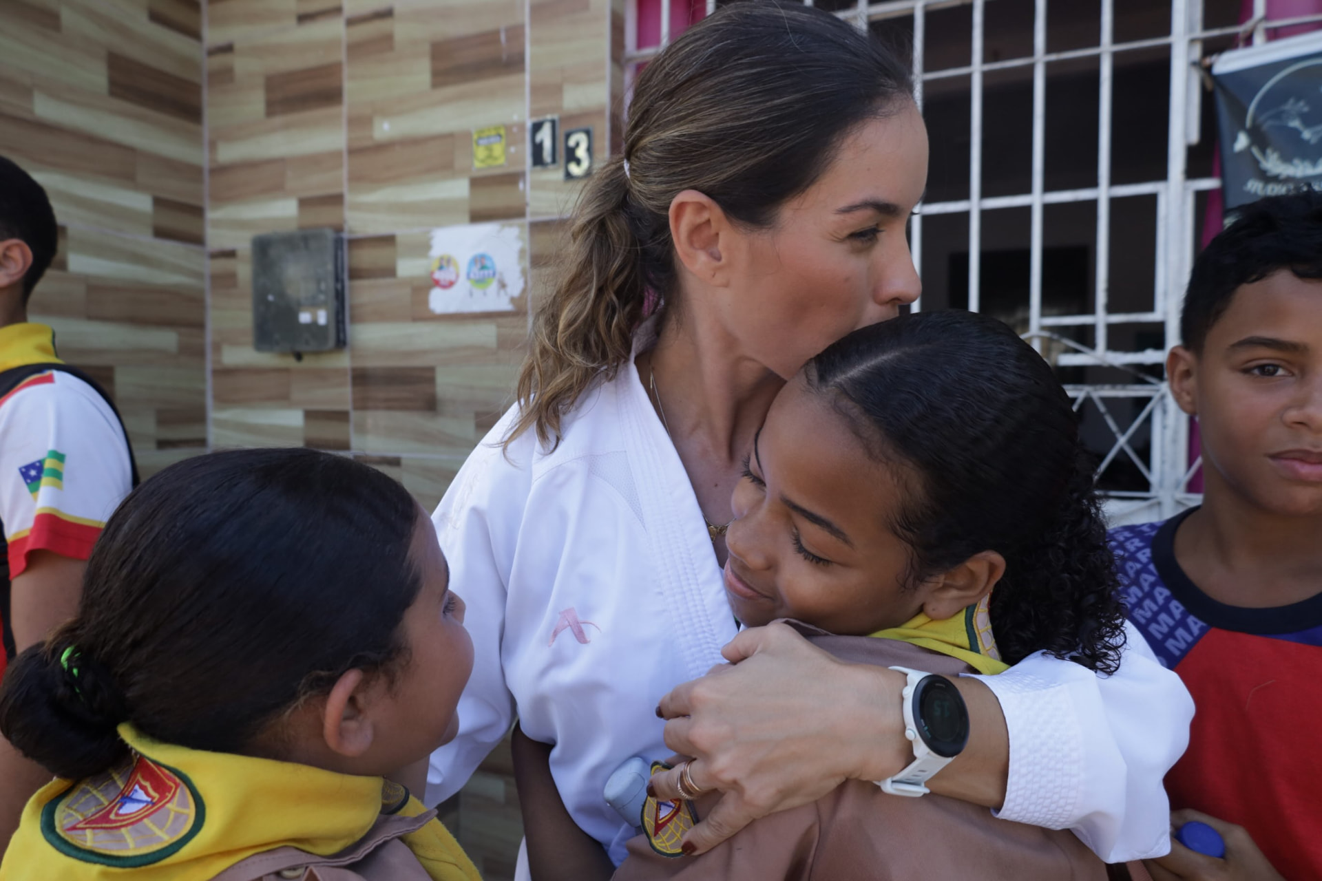 Mariana Dantas abraçando uma criança durante o desfile dos Desbravadores