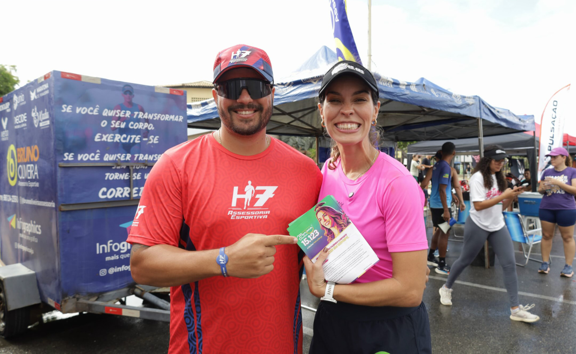 Mariana Dantas ao lado de apoiador mostrando o santinho 15.123 durante o treinão